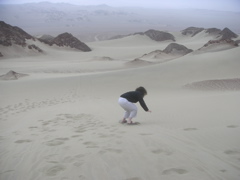 Janet "attempting" sandboarding. We got out of the dune buggies briefly to play around.